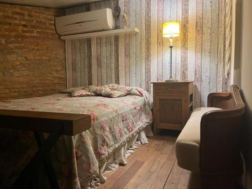 a bedroom with a bed and a table with a television on the wall at loft de diseño in Paysandú