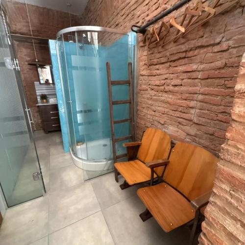 a bathroom with a shower and a wooden chair at loft de diseño in Paysandú