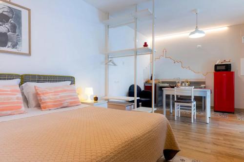 a bedroom with a bed and a table with a kitchen at dimora Spine Bianche in Matera