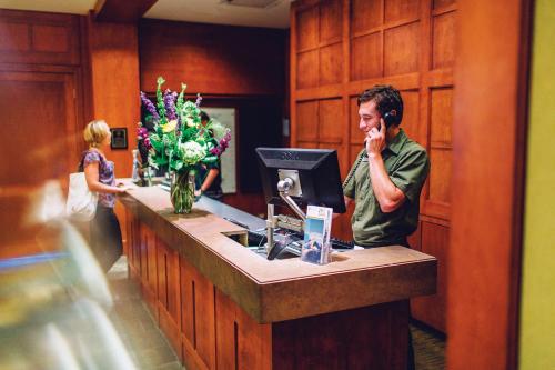 a man talking on a phone at a reception desk at Pan Pacific Whistler Mountainside in Whistler