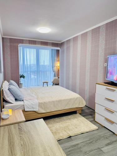 een slaapkamer met een bed en een televisie. bij 2 rooms apartment central part in Ternopilʼ