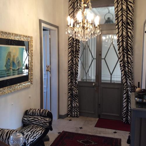 - un salon avec un lustre, une chaise et une porte dans l'établissement Les Lamartine-chambres d'hôtes, au Mans