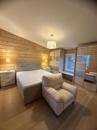 a bedroom with a bed and a couch and a chair at Best Cottage in Ruokolahti