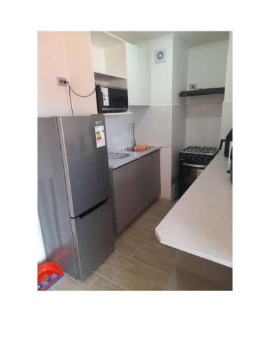 een keuken met een roestvrijstalen koelkast bij Condominio Vista Reloncavi in De Cauquenes