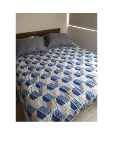 een bed met een blauw en wit dekbed bij Condominio Vista Reloncavi in De Cauquenes