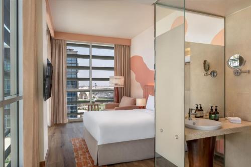 a hotel room with a bed and a sink at Yas Plaza Circuit by IHG in Abu Dhabi
