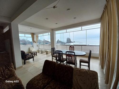 een woonkamer met een bank, een tafel en stoelen bij Beach House in Punta Negra