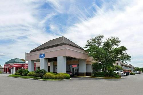 a store front of a building with a parking lot at Heritage Inn & Suites by Capital O Baton Rouge I 10 in Baton Rouge