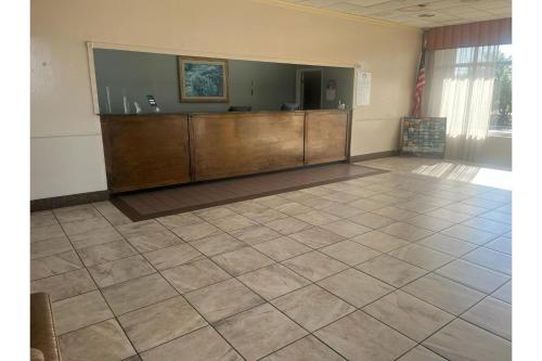 a large room with a reception desk and a tiled floor at Heritage Inn & Suites by Capital O Baton Rouge I 10 in Baton Rouge