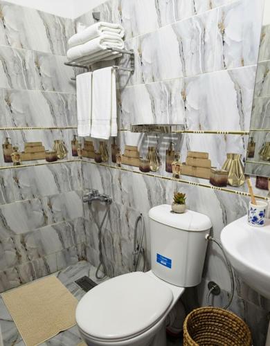 a bathroom with a toilet and a sink and towels at Riad Dalia - Fes Medina in Fez