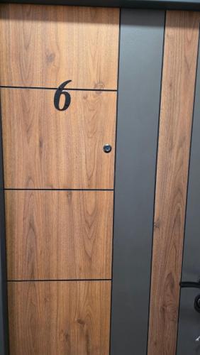 eine hölzerne Kommode mit der Zahl sechs darauf in der Unterkunft Gold Apartman in Veternik