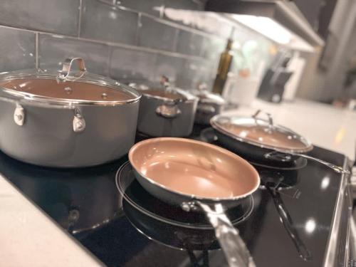 three pots and pans on a stove in a kitchen at The Nichols Lux Fort Worth TX Same Day Booking in Fort Worth