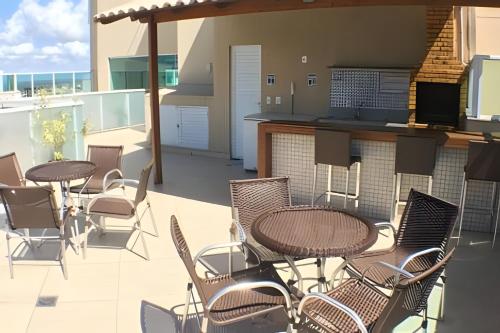 eine Terrasse mit Tischen und Stühlen auf einem Balkon in der Unterkunft PRAIA DE ITAPARICA BEACH 24HRS in Vila Velha