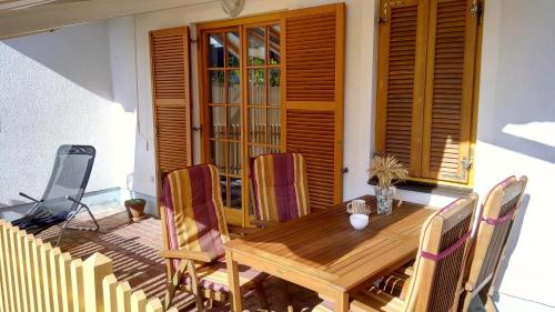 Una mesa y sillas de madera en un patio. en Apartment Pika, en Moravske Toplice