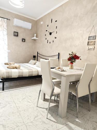 ein Schlafzimmer mit einem Tisch und einem Bett mit einer Uhr in der Unterkunft Da Nonno Mario in Bagnoli Irpino