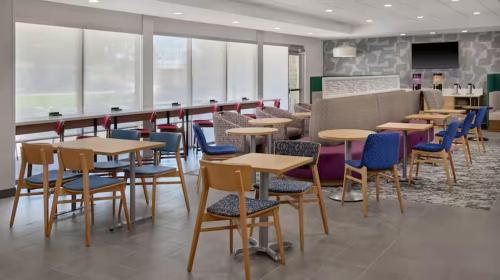 a dining room with tables and chairs in a cafeteria at Home 2 Suites by Hilton Frankenmuth in Frankenmuth