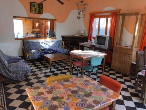een woonkamer met een tafel en stoelen bij Estrella Vladimir Hostel in Capilla del Monte