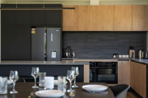 a kitchen with a table with glasses on it at Te Maunga Retreat | Views, Space & Near Ski Fields in Frankton