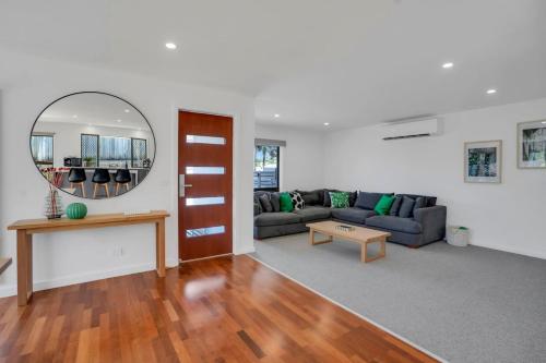 a living room with a couch and a mirror at Goonawarra Getaway at Mooloolaba in Mooloolaba