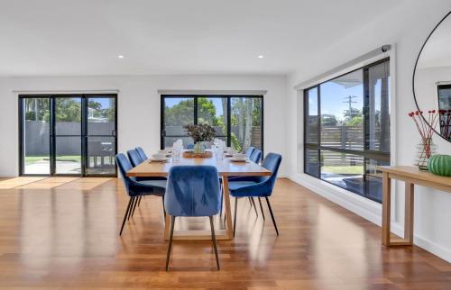 a dining room with a table and blue chairs at Goonawarra Getaway at Mooloolaba in Mooloolaba