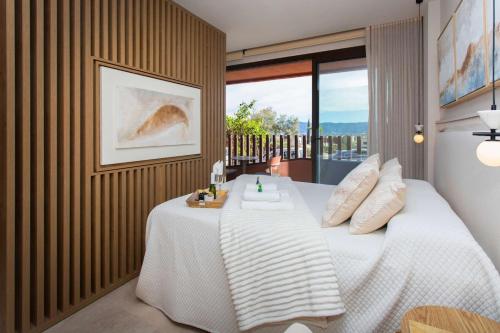 ein Schlafzimmer mit einem weißen Bett und einem Balkon in der Unterkunft Le Petit Palace in Guadalupe