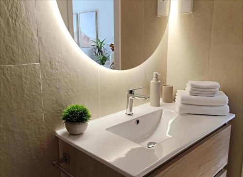 ein Badezimmer mit Waschbecken und Spiegel in der Unterkunft Le Petit Palace in Guadalupe