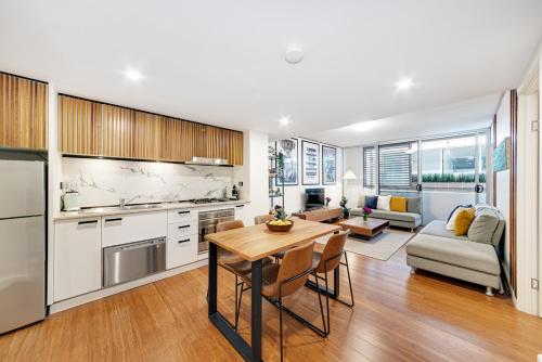 a kitchen and living room with a table and a couch at DREWS CBD Central Haven 3 min to Oxford St in Sydney