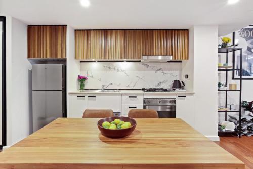 a kitchen with a wooden table with a bowl of fruit on it at DREWS CBD Central Haven 3 min to Oxford St in Sydney