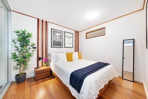 a bedroom with a bed and a potted plant at DREWS CBD Central Haven 3 min to Oxford St in Sydney