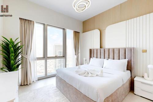 ein Schlafzimmer mit einem großen Bett mit einem großen Fenster in der Unterkunft DIRECT BURJ KHALIFA ONLY 2 MINUTES AWAY in Dubai