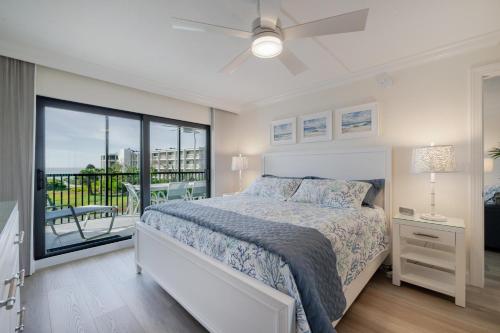 YbelSand Pointe 226的一间带床和阳台的白色卧室