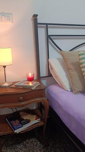 een bed met een tafeltje en een kaars ernaast bij Centurion's House in Genua