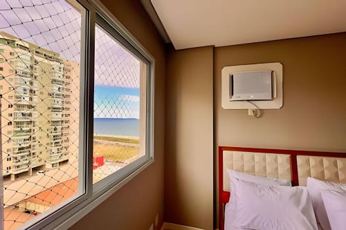 une chambre avec une fenêtre avec vue sur l'océan dans l'établissement PRAIA & Sol: Apto Itaparica 2 Quartos, à Itaparica