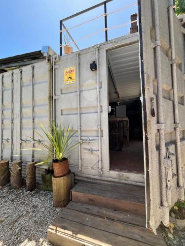una porta aperta di un edificio con una pianta in vaso di Complejo Bosque Verde a La Porteña