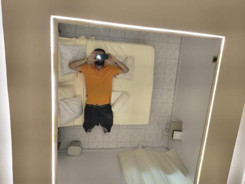 een man die een foto maakt in een badkuip bij LuxeStay in Santa Marta in Gaira