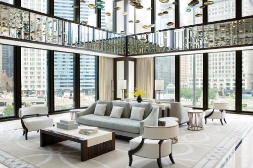 a living room with a couch and chairs and windows at The Langham Chicago in Chicago