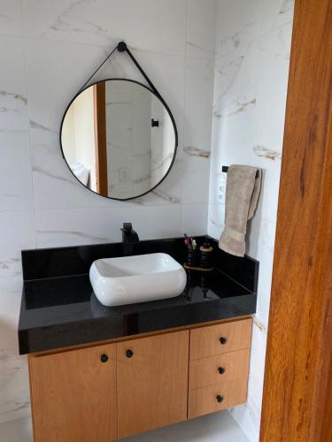 a bathroom with a sink and a mirror at Estância da Colina Chalet in Venda Nova do Imigrante