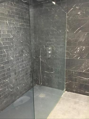ein Badezimmer mit einer Glasdusche mit Ziegelwand in der Unterkunft Villa piscine carnon plage in Mauguio