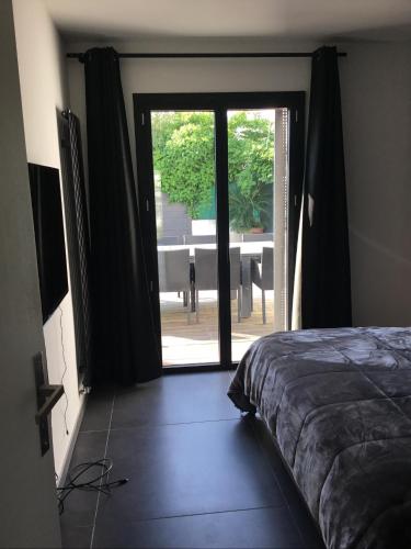 ein Schlafzimmer mit Glasschiebetür mit Blick auf eine Terrasse in der Unterkunft Villa piscine carnon plage in Mauguio