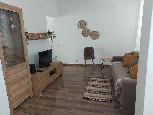 een woonkamer met een bank en een tv bij Casa do largo in Olhão