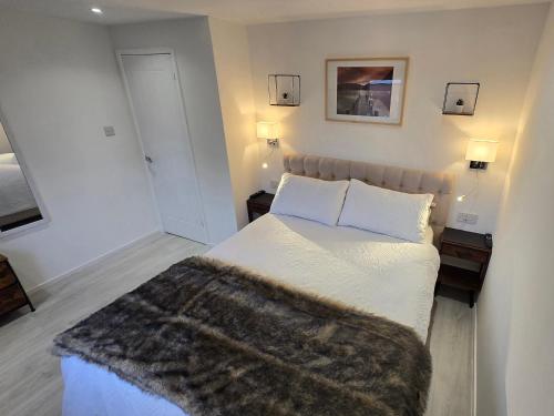 een slaapkamer met een bed met een harige deken erop bij Modern 1 bedroom riverside apartment in Ayr