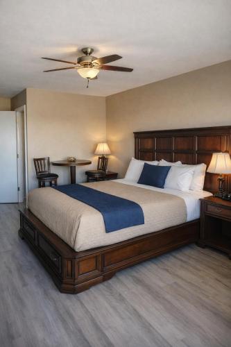 a bedroom with a large bed with a ceiling fan at Venice Inn Motel in Venice