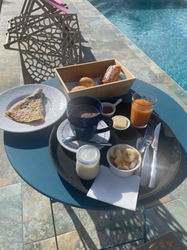 uma bandeja de comida numa mesa ao lado de uma piscina em Mango-passion Le Domaine Mannou em Sainte-Rose