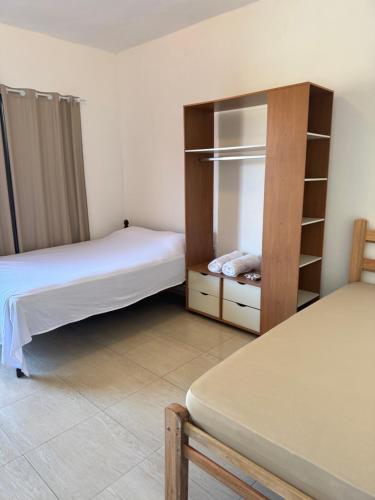 a bedroom with two beds and a book shelf at Studio Park e Mar a 600m do Beto Carrero in Penha