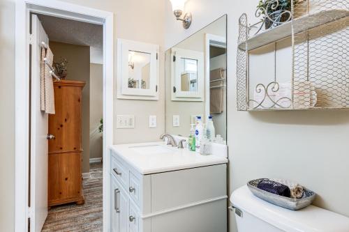 a white bathroom with a sink and a mirror at Fire Pit and Boat Dock Lake Chatuge Townhome! in Hiawassee