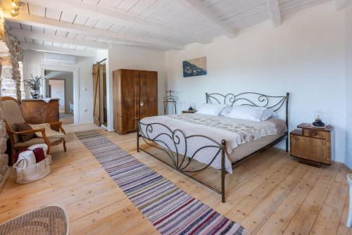 a bedroom with a bed and a chair and wooden floors at Villa Natalia in Grižane