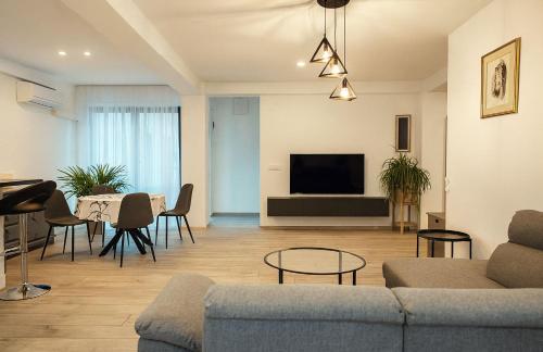 een woonkamer met een bank en een tafel bij Vodno Apartment - Top location and private parking in Skopje