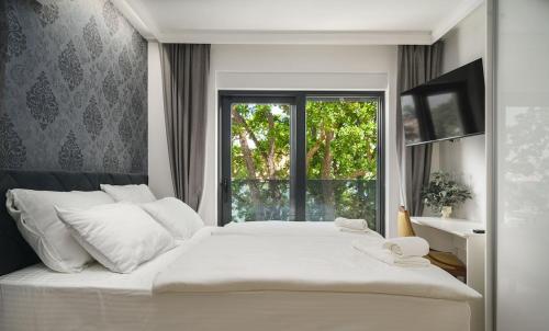 een slaapkamer met een groot wit bed en een raam bij Quercus Vodice in Vodice