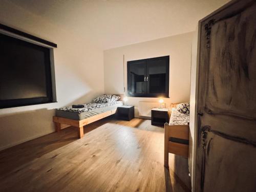 een kamer met 2 bedden, een tafel en 2 ramen bij Hiddenhausen Premium Apartment in Hiddenhausen