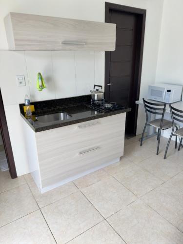 a kitchen with a sink and a table with chairs at Classe pousada in Imbé